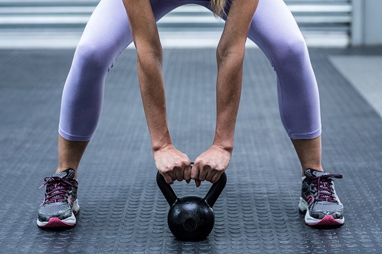 woman exercising with kettlebell