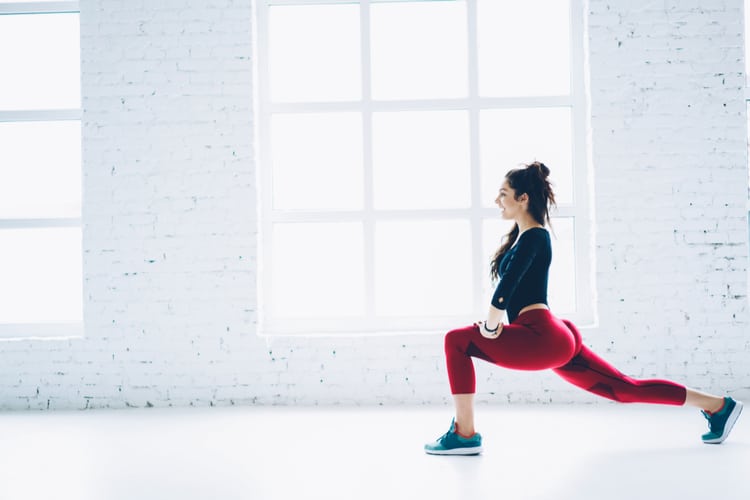 Woman doing lunges in red pants